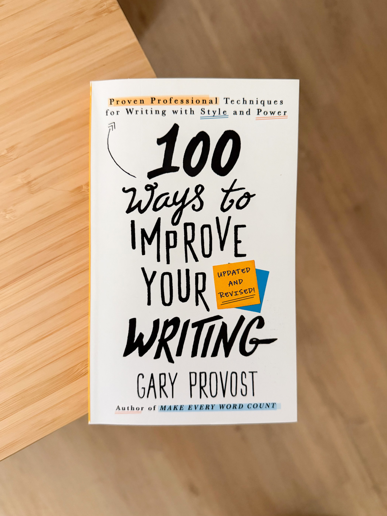 Libro '100 Ways to Improve Your Writing' de Gary Provost sobre una mesa de madera